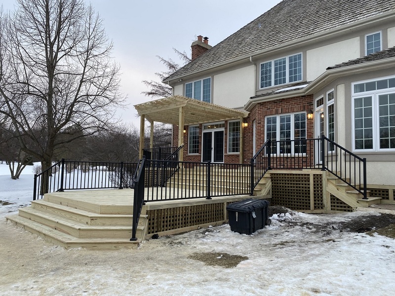 Pressure treated wooden deck with pergola in winter time